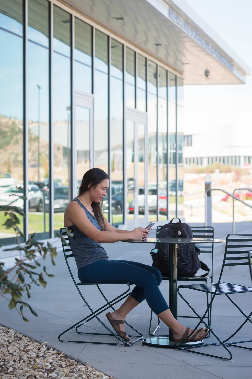 student sitting outside of the hybl center on their phone